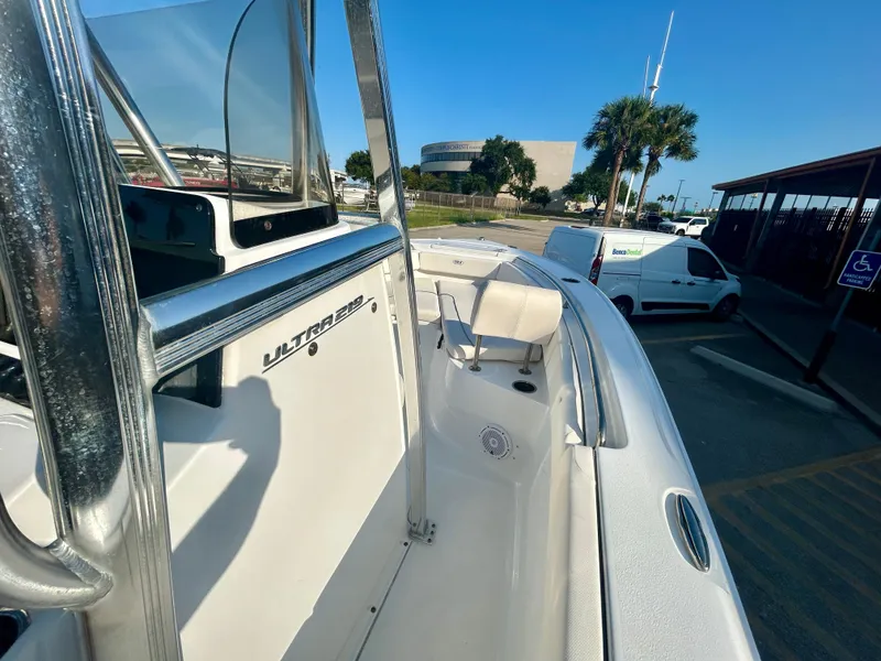 Slide: The Image of 2023 Sea Hunt Ultra 219 boat parked in a sunny lot with palm trees. - 19