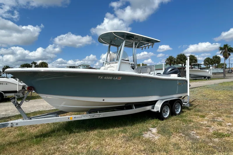 Slide: The Image of 2023 Sea Hunt Ultra 219 boat on trailer under blue sky. - 2