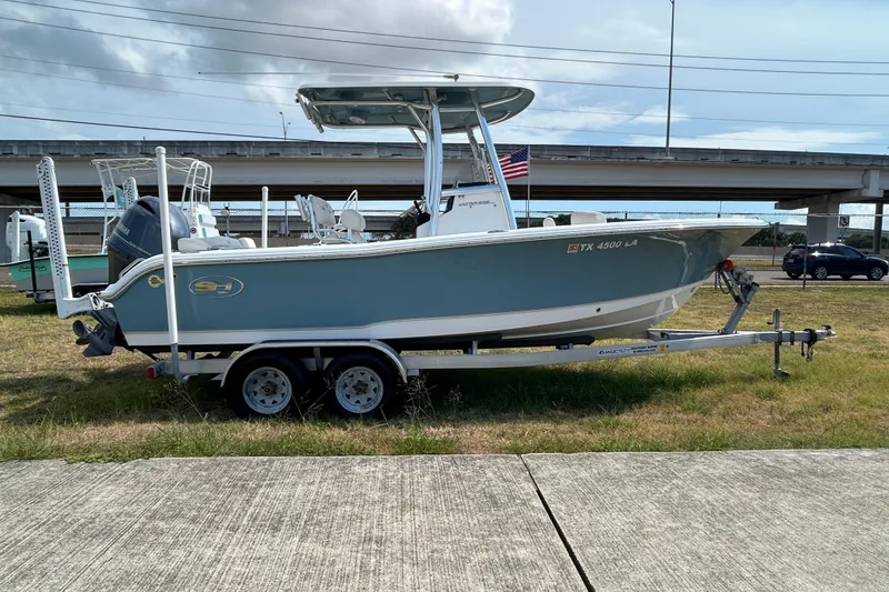 Slide: The Image of 2023 Sea Hunt Ultra 219 boat on trailer, parked on grass near highway. - 5