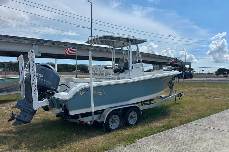 Slide: The Image of 2023 Sea Hunt Ultra 219 boat on trailer, parked outdoors under a clear sky. - 6