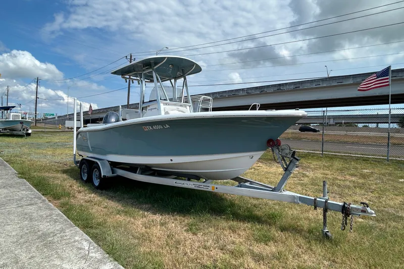 Slide: The Image of 2023 Sea Hunt Ultra 219 boat on trailer, parked outdoors under cloudy sky. - 7