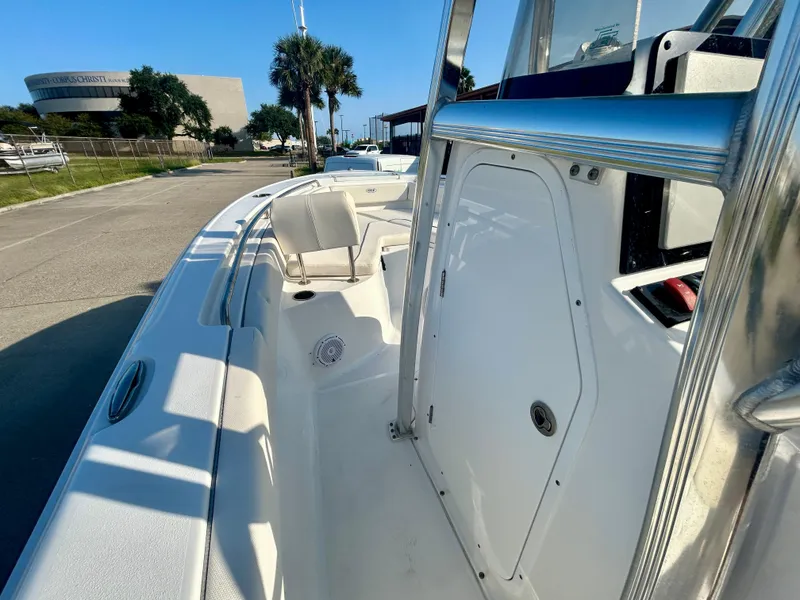 Slide: The Image of 2023 Sea Hunt Ultra 219 boat, white interior, docked under clear blue sky. - 9