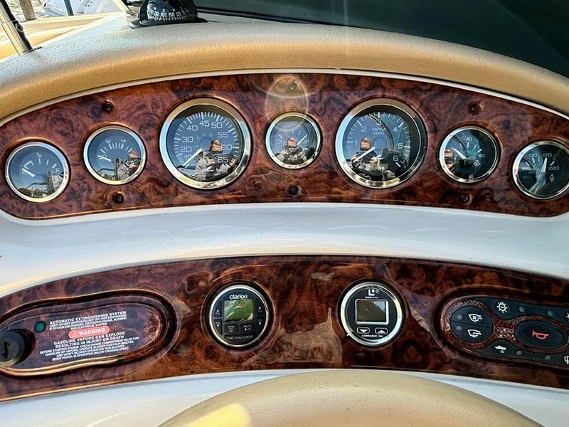 Slide: The Image of Dashboard of a 2002 Sea Ray 240 Sundeck boat with wood grain finish and gauges. - 13