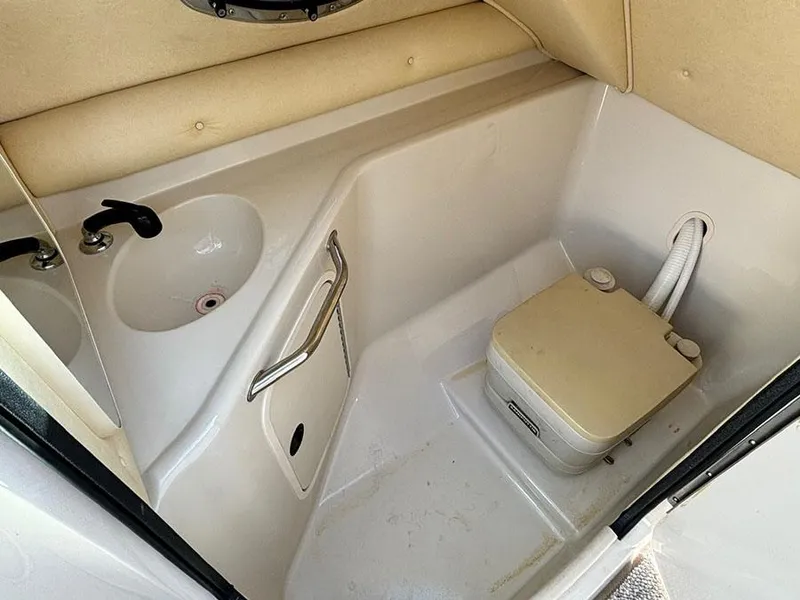 Slide: The Image of 2002 Sea Ray 240 Sundeck interior with sink and portable toilet. - 15