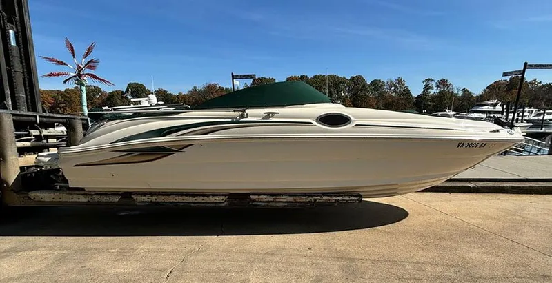 Slide: The Image of 2002 Sea Ray 240 Sundeck boat on a dock under clear blue sky. - 2