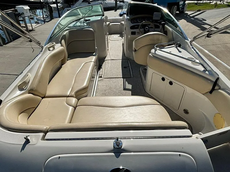 Slide: The Image of 2002 Sea Ray 240 Sundeck interior with beige seating and dashboard view. - 22