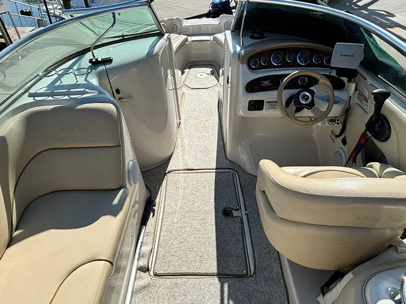 Slide: The Image of 2002 Sea Ray 240 Sundeck interior with beige seating and steering console. - 4