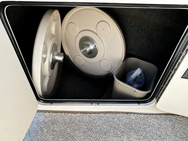 Slide: The Image of Storage compartment in 2002 Sea Ray 240 Sundeck with table tops and trash bin. - 8