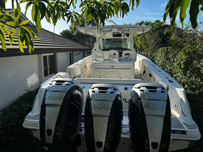 Slide: The Image of 2014 Boston Whaler 370 Outrage boat with triple 400 horsepower engines, docked near a house. - 4