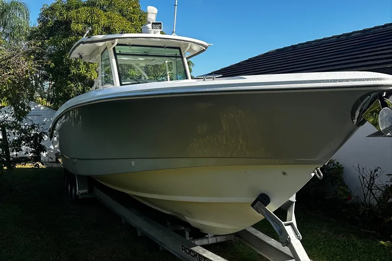 Slide: The Image of 2014 Boston Whaler 370 Outrage boat on trailer, parked outdoors. - 6