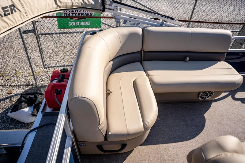 Slide: The Image of 2025 Sun Tracker Bass Buggy 16 DLX pontoon boat with beige seating and storage. - 12