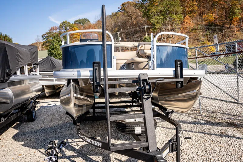 Slide: The Image of 2025 Sun Tracker Bass Buggy 16 DLX pontoon boat on trailer, parked outdoors. - 5