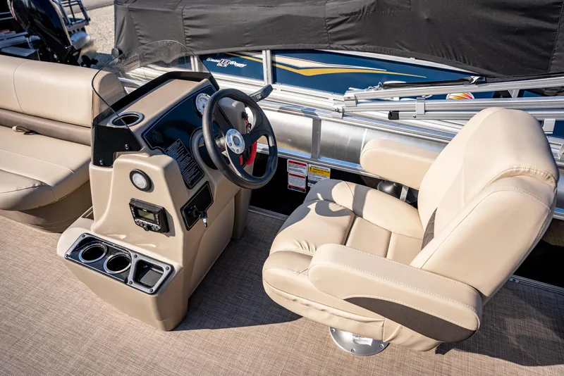 Slide: The Image of 2025 Sun Tracker Party Barge 16 interior with beige seating and steering console. - 10