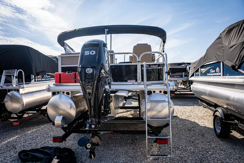 Slide: The Image of 2025 Sun Tracker Party Barge 16 pontoon boat with 50 HP engine, parked outdoors. - 4