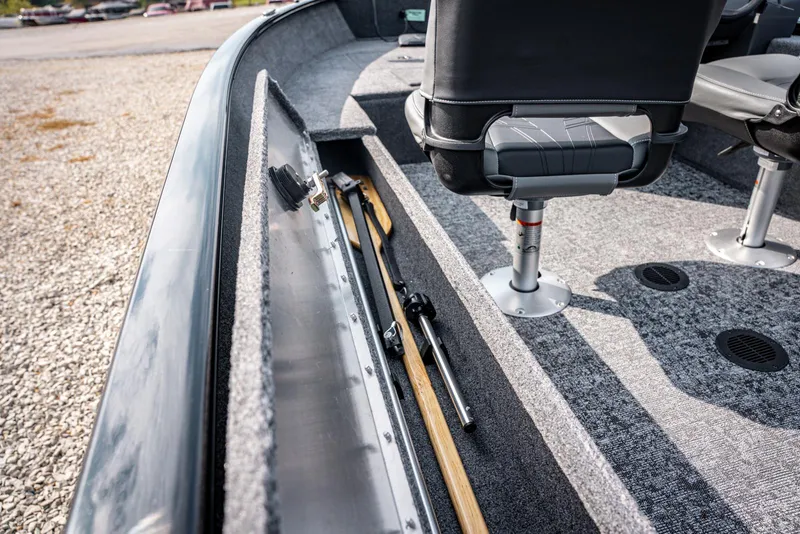 Slide: The Image of 2025 Bass Tracker Super Guide V-16 SC boat interior with rod storage and seating. - 11