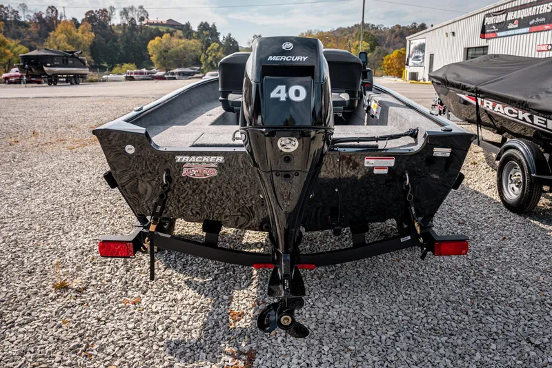 Slide: The Image of 2025 Bass Tracker Super Guide V-16 SC boat with Mercury 40 engine, parked on gravel. - 4