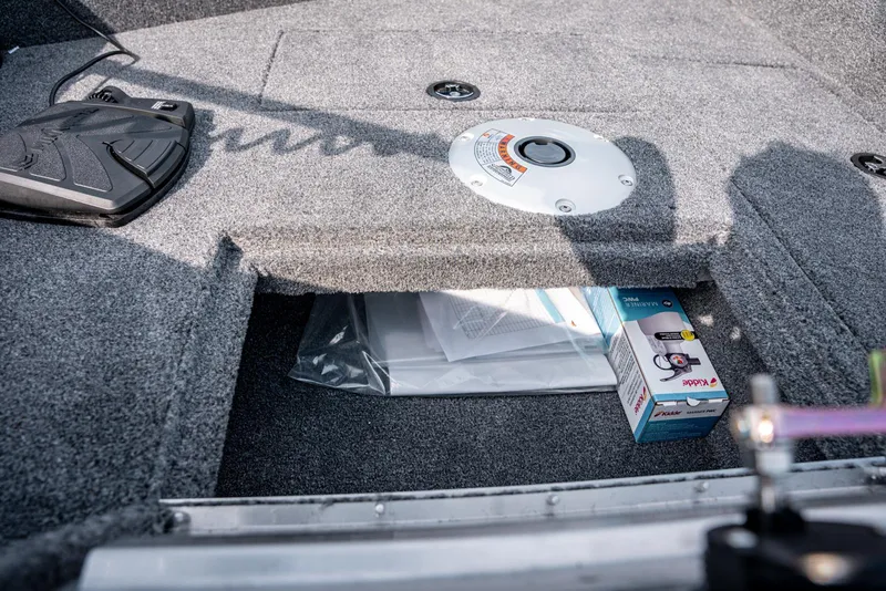Slide: The Image of 2025 Bass Tracker Super Guide V-16 SC storage compartment with carpeted interior and accessories. - 8