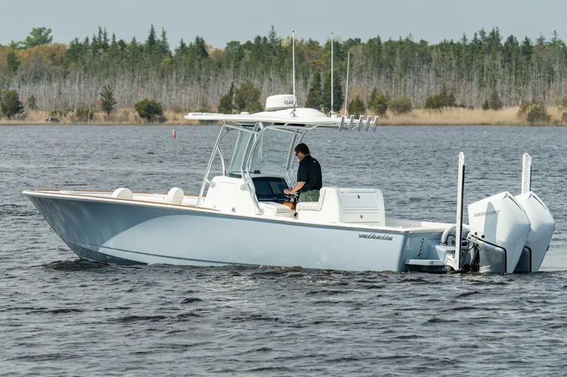 Slide: The Image of 2025 Valhalla Boatworks V-29 Hybrid cruising on a lake with a person at the helm. - 21