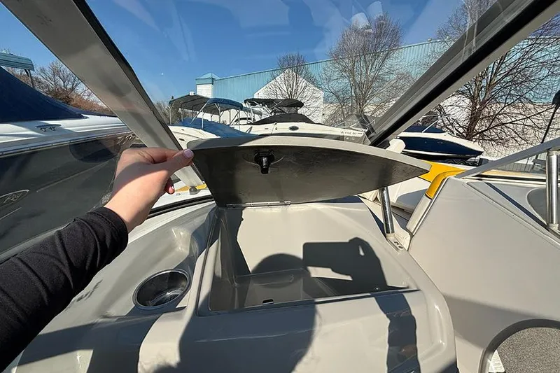 Slide: The Image of 2012 Bayliner 185 Bowrider interior with open storage compartment and cup holder. - 18