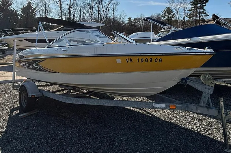 Slide: The Image of 2012 Bayliner 185 Bowrider boat on trailer, yellow and white, parked outdoors. - 7