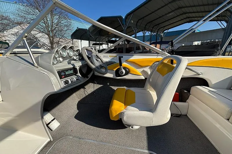 Slide: The Image of 2012 Bayliner 185 Bowrider interior with steering wheel, dashboard, and yellow-accented seating. - 8