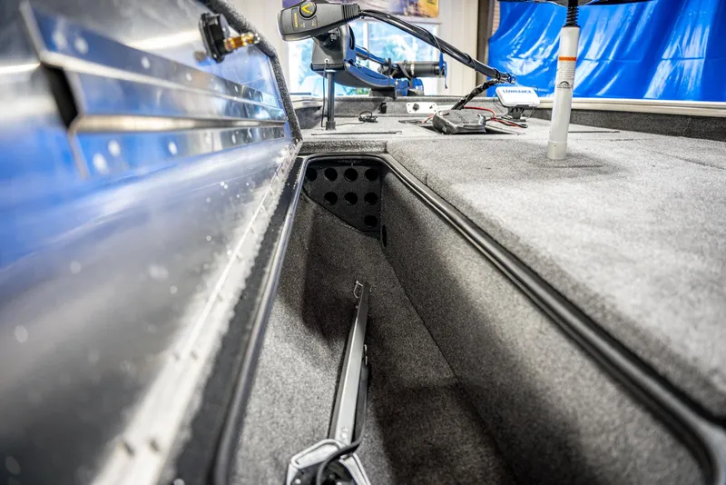 Slide: The Image of 2025 Bass Tracker PRO TEAM 190 interior storage compartment with fishing rod holder. - 11
