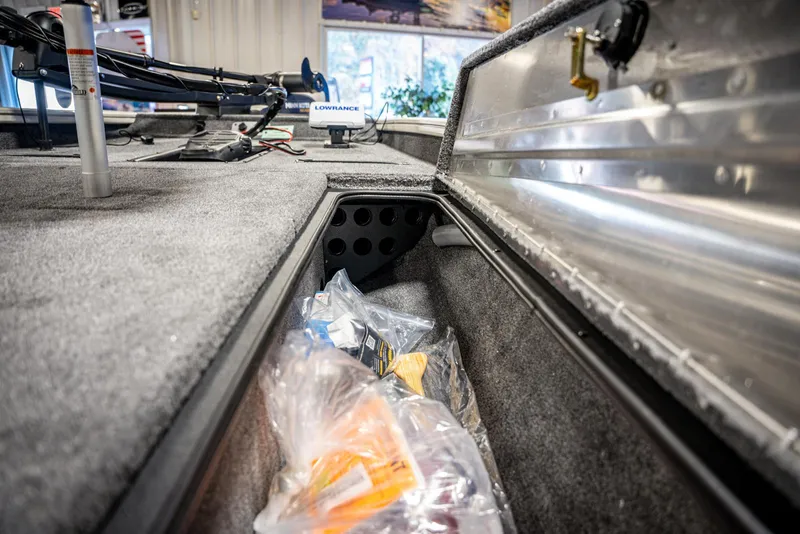 Slide: The Image of 2025 Bass Tracker PRO TEAM 190 boat storage compartment with fishing gear. - 9