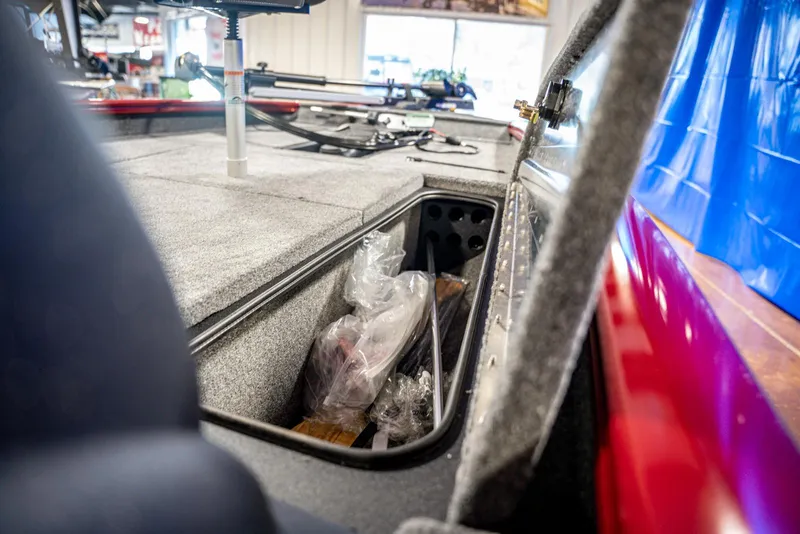 Slide: The Image of 2025 Bass Tracker Pro Team 175 boat storage compartment with fishing gear. - 7