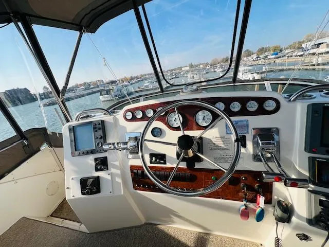 Slide: The Image of 1999 Silverton 392 Motor Yacht helm with steering wheel and navigation instruments. - 10