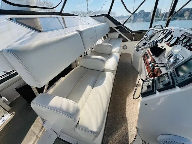 Slide: The Image of Interior of 1999 Silverton 392 Motor Yacht with white seating and control panel. - 11