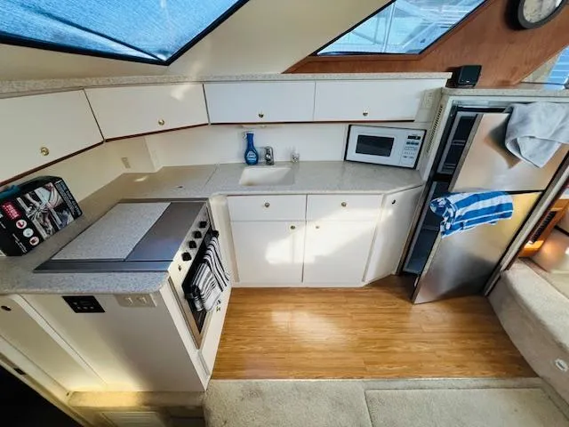 Slide: The Image of Interior of 1999 Silverton 392 Motor Yacht kitchen with stove, sink, and refrigerator. - 18