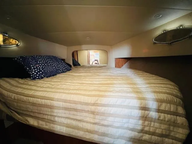 Slide: The Image of Cozy bedroom interior of 1999 Silverton 392 Motor Yacht with striped bedding. - 19
