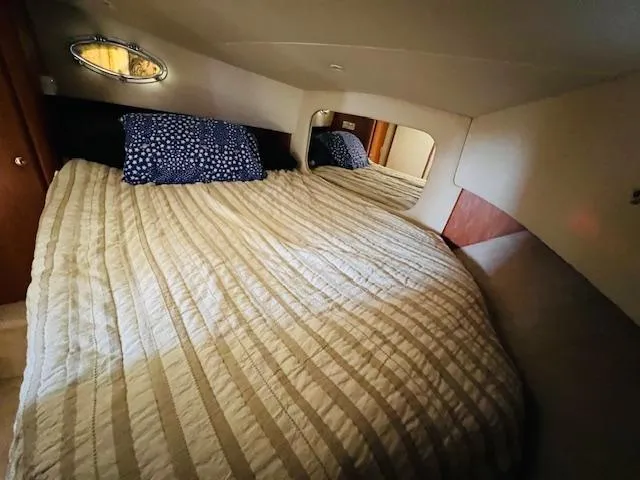 Slide: The Image of Cozy bedroom in 1999 Silverton 392 Motor Yacht with striped bedding and porthole window. - 20