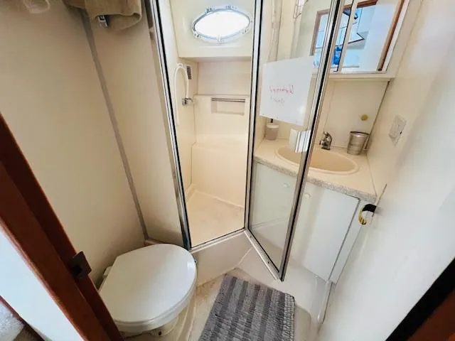 Slide: The Image of 1999 Silverton 392 Motor Yacht bathroom with shower, toilet, and sink. - 21