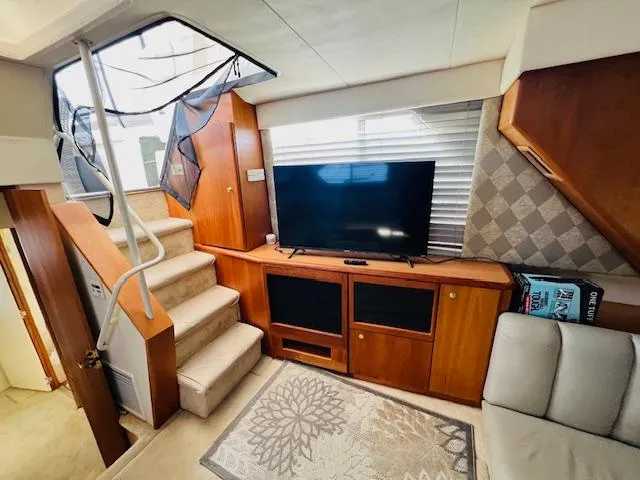 Slide: The Image of Interior of 1999 Silverton 392 Motor Yacht with TV, stairs, and cozy seating area. - 24