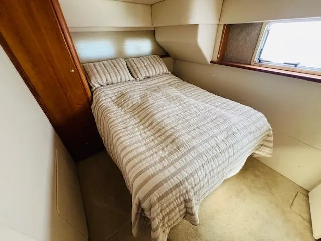 Slide: The Image of Cozy bedroom in 1999 Silverton 392 Motor Yacht with striped bedding and window view. - 25