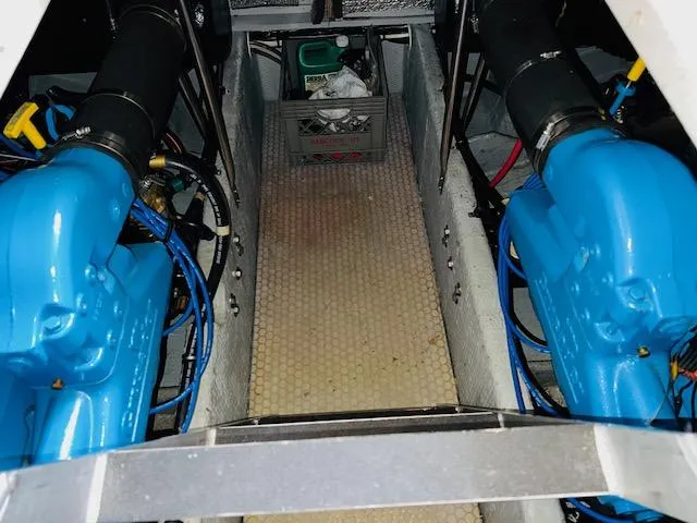 Slide: The Image of Engine room of 1999 Silverton 392 Motor Yacht with blue engines and storage crate. - 32