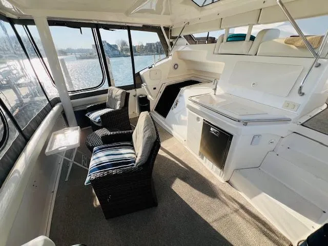 Slide: The Image of 1999 Silverton 392 Motor Yacht interior with seating and kitchenette, overlooking water. - 6