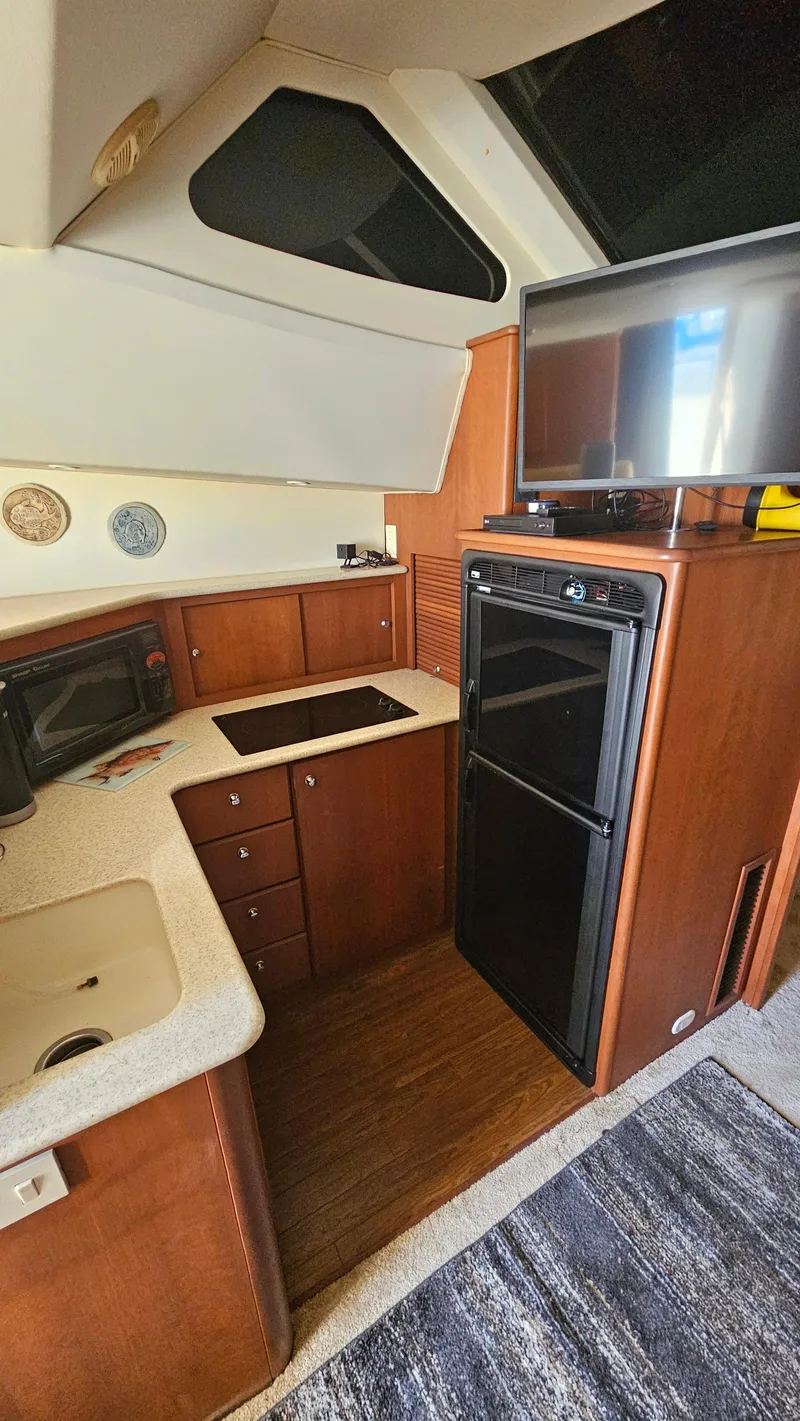 Slide: The Image of 2005 Silverton 330 Sport Bridge kitchen with modern appliances and wood cabinetry. - 11