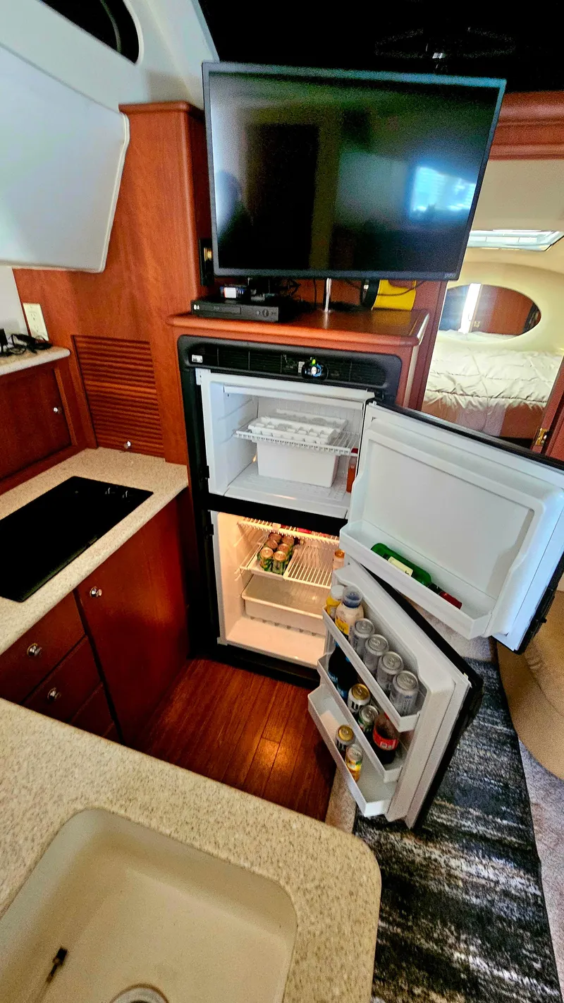 Slide: The Image of 2005 Silverton 330 Sport Bridge interior with open fridge and TV. - 12