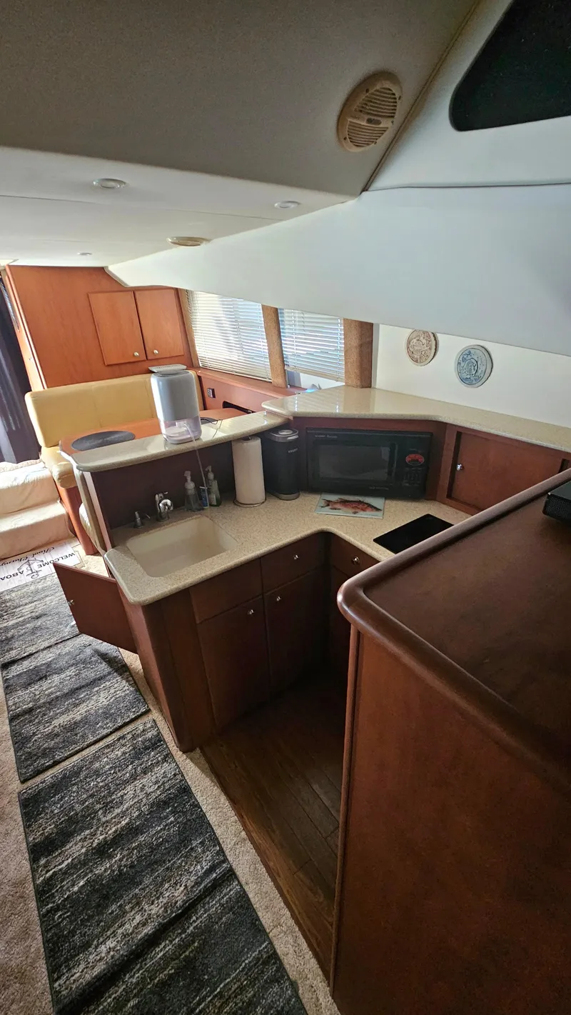 Slide: The Image of 2005 Silverton 330 Sport Bridge interior with kitchen and seating area. - 14