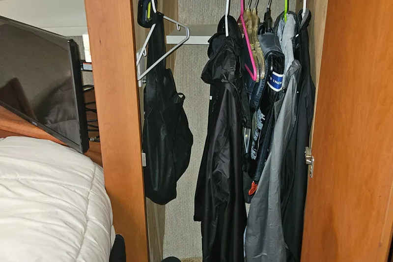 Slide: The Image of Closet inside 2005 Silverton 330 Sport Bridge with hanging clothes and jackets. - 25