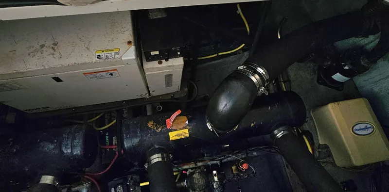 Slide: The Image of Engine room of a 2005 Silverton 330 Sport Bridge with visible pipes and machinery. - 42