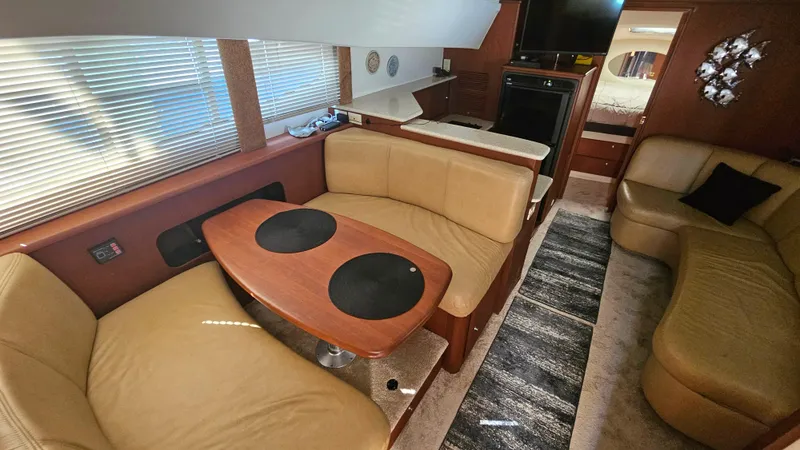 Slide: The Image of 2005 Silverton 330 Sport Bridge interior with cozy seating and dining area. - 7