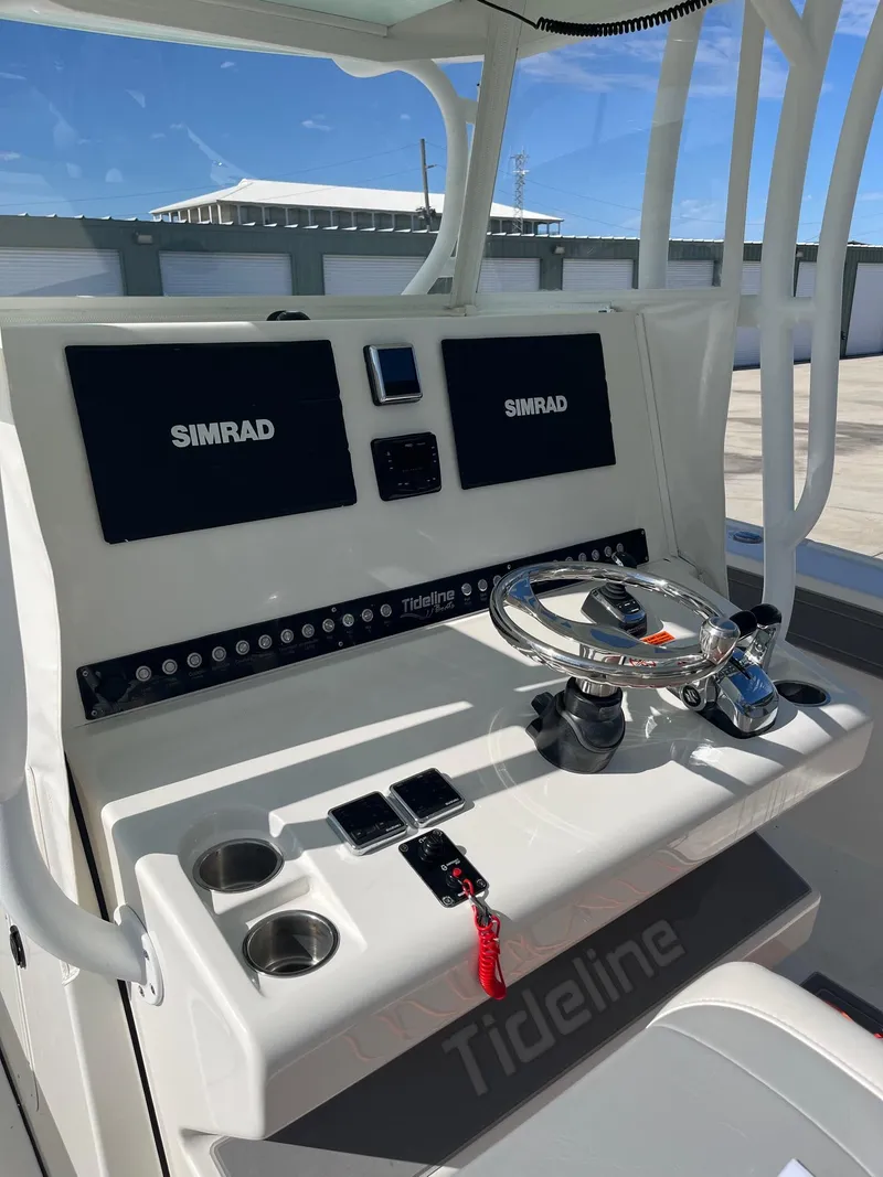Slide: The Image of 2021 Tideline 365 boat console with dual Simrad displays and steering wheel. - 26