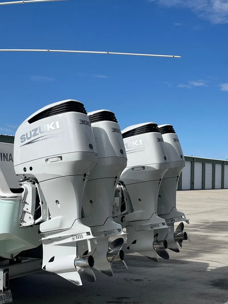 Slide: The Image of Tideline 365 boat with triple Suzuki outboard motors, 2021 model, parked outdoors. - 8