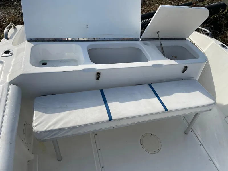 Slide: The Image of Edgewater 247CC 2000 boat interior with storage compartments and cushioned bench seat. - 21