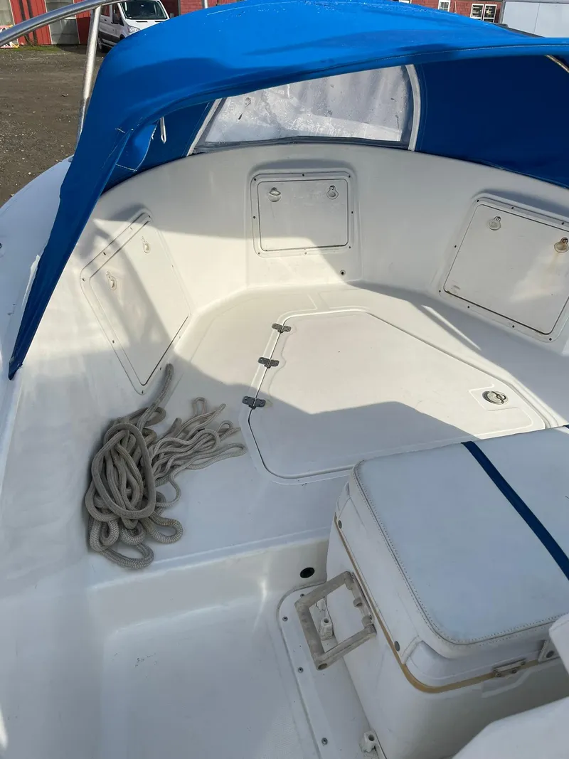 Slide: The Image of Edgewater 247CC boat interior with blue canopy and coiled rope, 2000 model. - 24