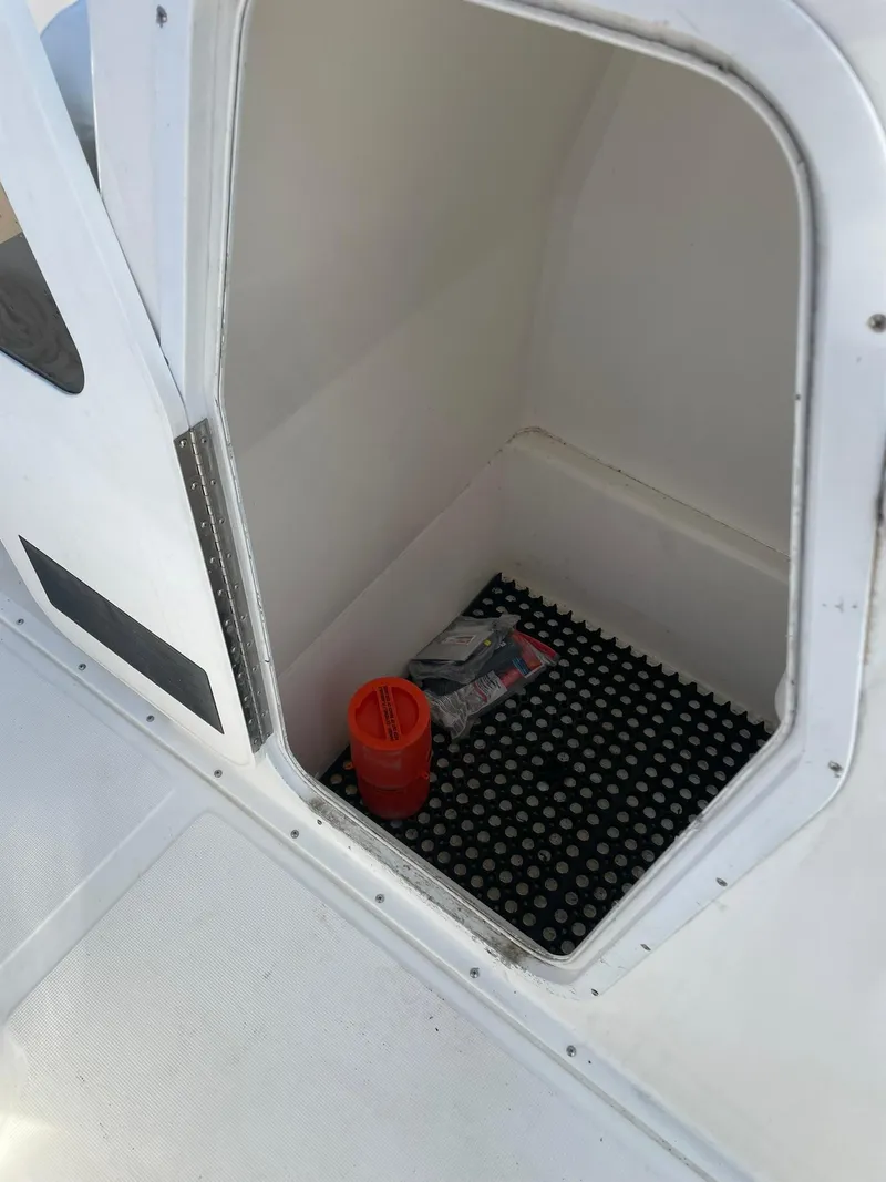 Slide: The Image of Storage compartment of a 2000 Edgewater 247CC boat with safety equipment inside. - 30