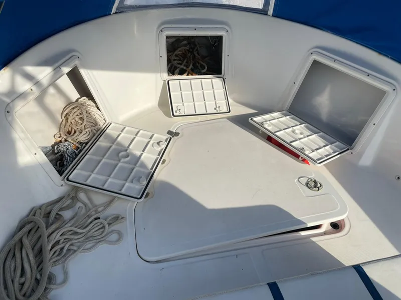 Slide: The Image of Open storage compartments on a 2000 Edgewater 247CC boat deck with ropes inside. - 33